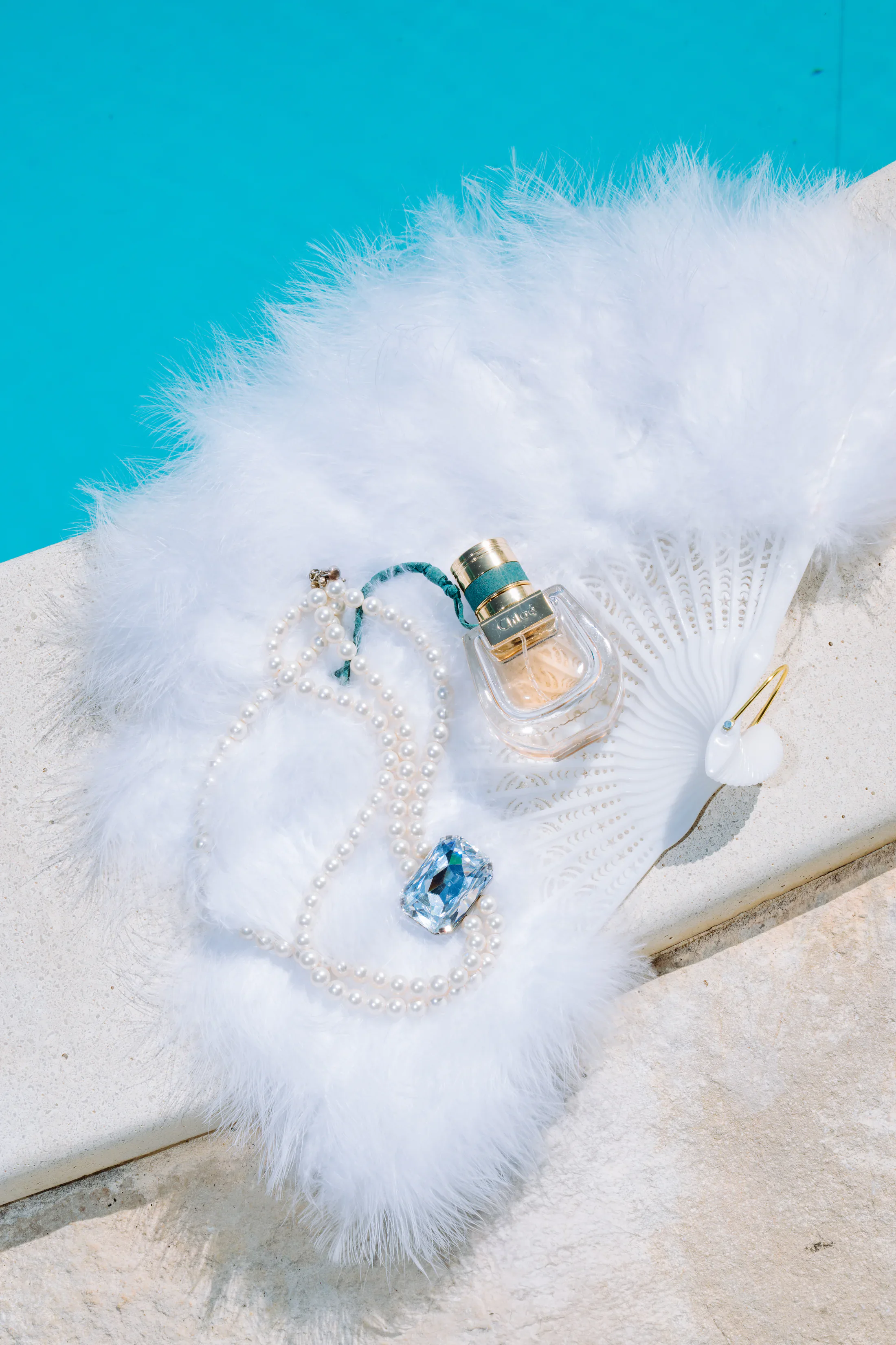 Bridal accessories styled beside a swimming pool
