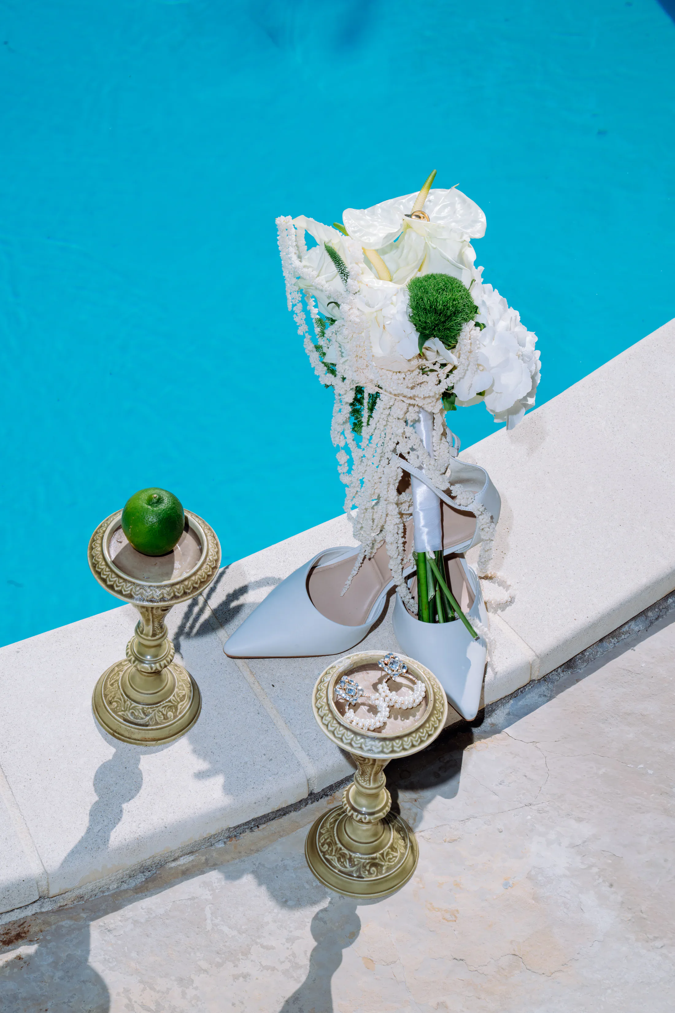 Editorial bridal details beside a turquoise pool