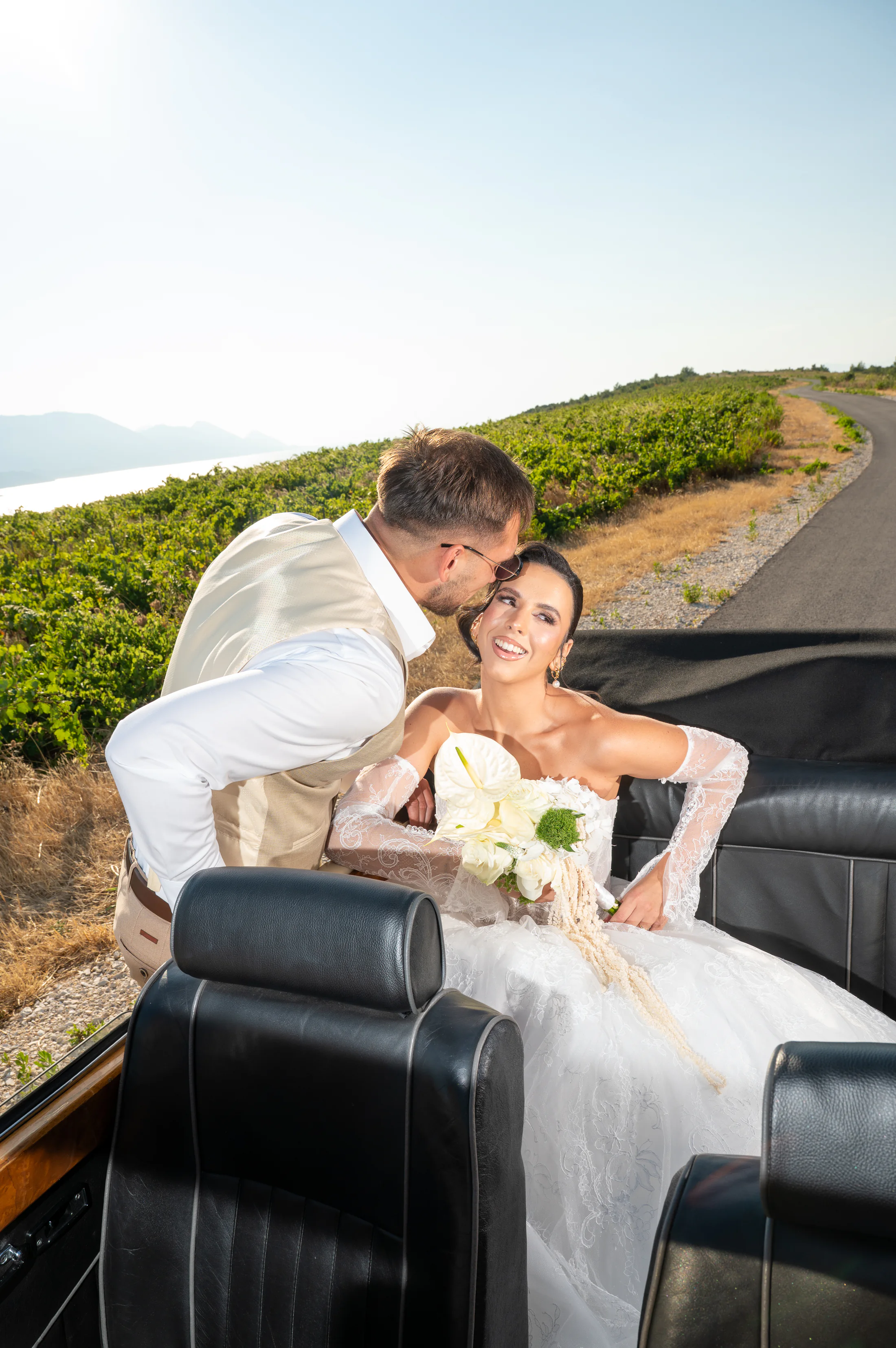 Bride and groom beside a vintage convertible