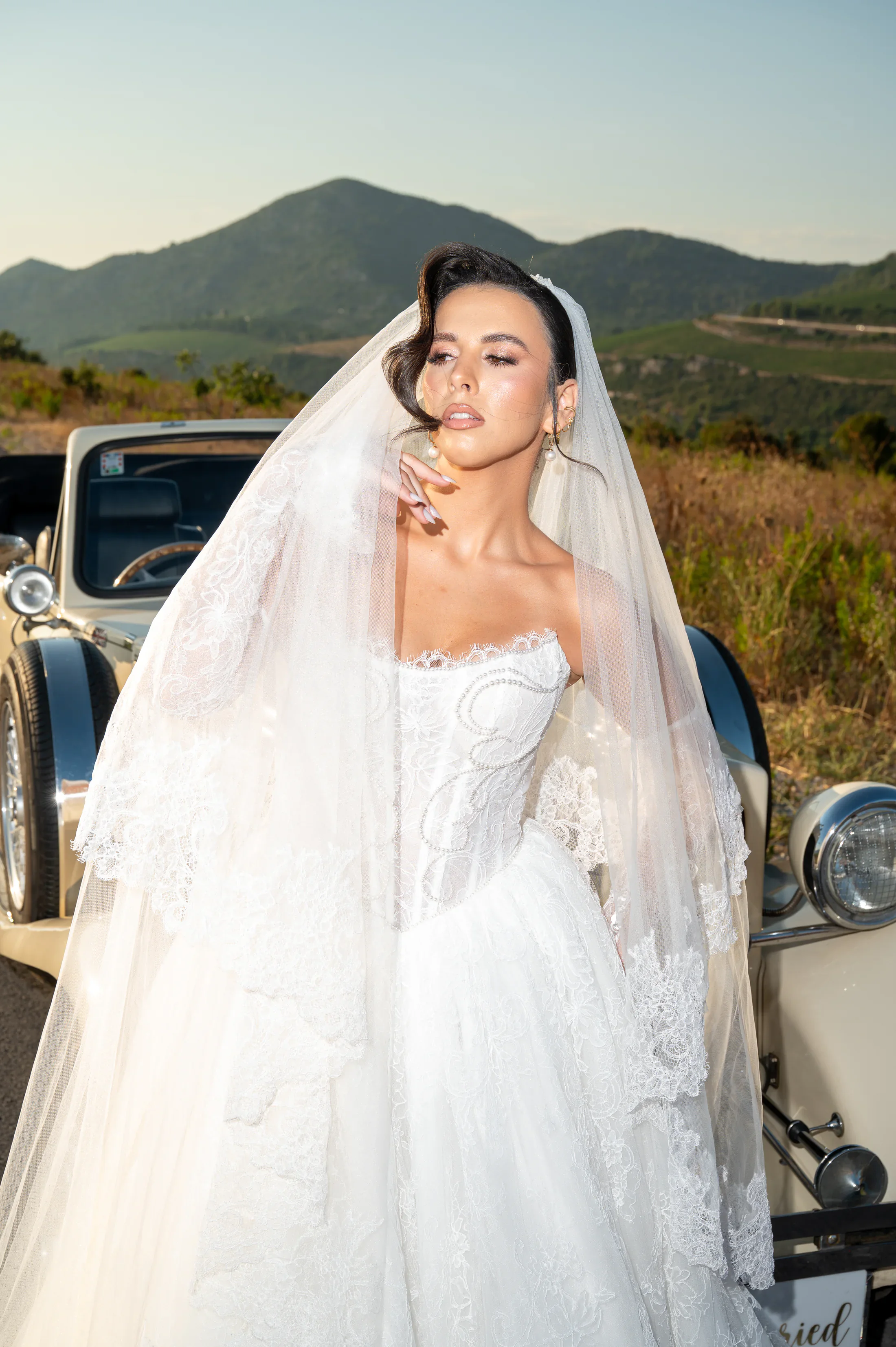Bride beside a vintage car in a Mediterranean vineyard